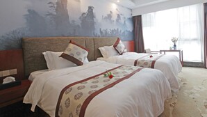 A hotel room with two beds, a nightstand, a small table, and a large window with curtains. - Days Hotel Zhangjiajie (Zhangjiajie)