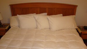 A bed with a wooden headboard, multiple pillows, and a blanket. - Tierra Del Sol 1 by MoabCondos4Rent (Moab)