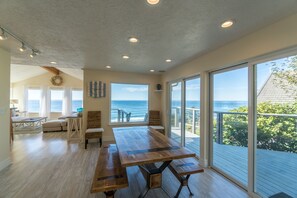 Enjoy ocean views from the dining area, which features a large table and benches.