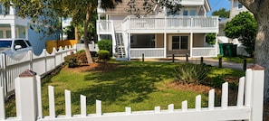 A two-story house with a front porch, a white picket fence, and a well-maintained lawn. - Cozy Coastal Retreat with Private Heated Pool Walk to Florida's Best Beaches (Destin)