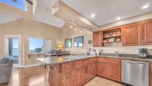 A spacious kitchen with wooden cabinets, a central island, and a dishwasher.