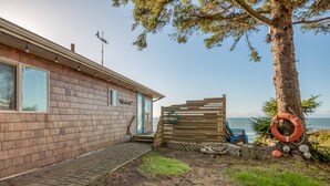 Une maison avec une façade en bois, une porte bien visible et un petit porche.