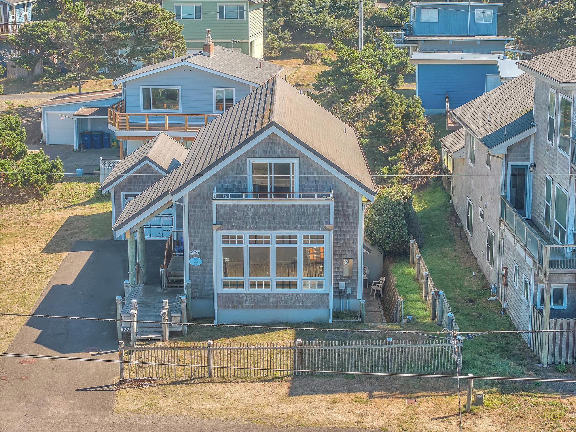 A single-story house with a front porch, a garage, and a fenced yard.