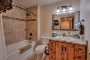 A bathroom with a bathtub, toilet, and sink. - Southgate 4 by MoabCondos4Rent (Moab)