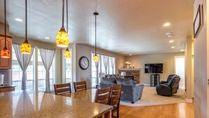 A spacious living area with a kitchen island, dining chairs, a sofa, and a fireplace. - Brookwood Manor (5 Bedroom, 14 Guests) (Hillsboro)