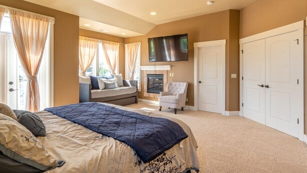 A bedroom with a large bed, a television mounted on the wall, and a fireplace. - Brookwood Manor (5 Bedroom, 14 Guests) (Hillsboro)