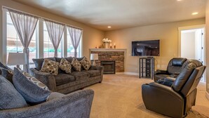 A living room with a sofa set, a recliner, a fireplace, and a flat-screen TV. - Brookwood Manor (5 Bedroom, 14 Guests) (Hillsboro)