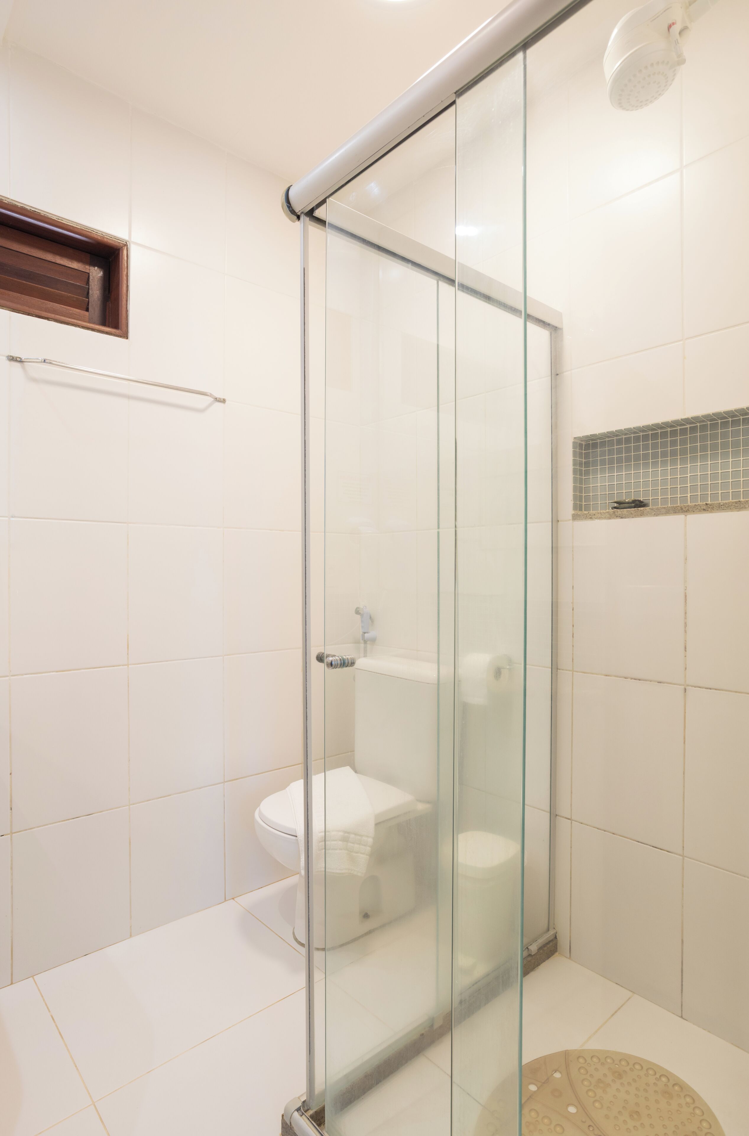 A modern bathroom with a glass-enclosed shower, a toilet, and a sink.