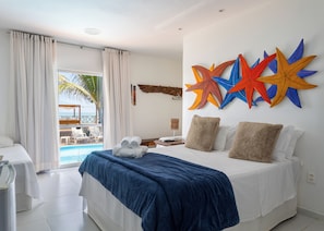 A hotel room with a bed, a view of a pool, and a beach. - Pousada Ipioca Beach Village (Maceió)