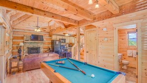 A wooden cabin with a pool table, a fireplace, and a kitchen area. - Mount LeConte Views, Genuine Log Cabin, Hot Tub, Easy Access Near Town, Fire Pit (Gatlinburg)
