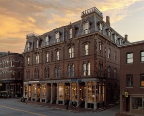 A historic building with large windows and a corner entrance, featuring a storefront with a sign that reads 'FREE PEOPLE'.