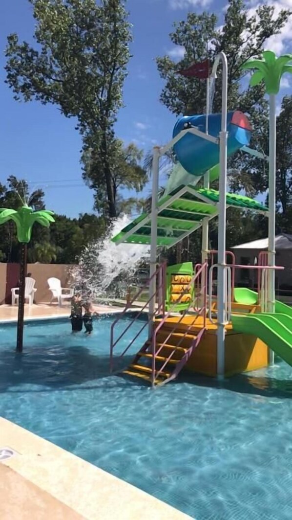 Una piscina al aire libre de temporada, sillones reclinables de piscina