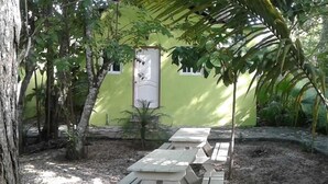 A patio area with wooden benches and a door leading to a building. - Green Jungle Hotel y Restaurante (Flores)