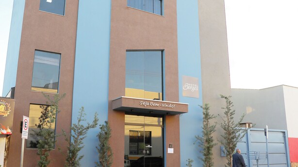 A modern hotel with a blue and brown facade, a visible entrance, and a sign reading "Hotel Georges." - Hotel Borges (Quirinopolis)