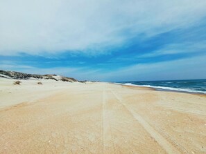 Uma praia com céu limpo e oceano.