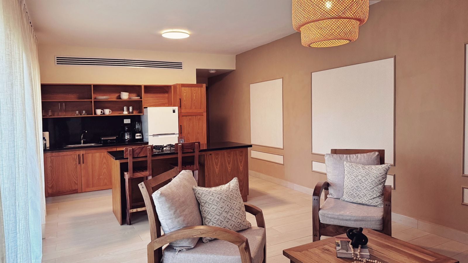 Ein modernes Wohnzimmer mit Essbereich, Holzmöbeln und einer Küche im Hintergrund.