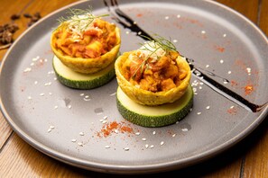 Duas tarteletes saborosas numa travessa com garfo e faca.
