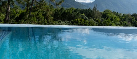 Una piscina al aire libre, sillones reclinables de piscina