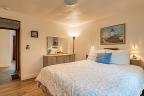 Ein Schlafzimmer mit einem großen Bett, einem Schminktisch, einem Spiegel und einem Bild an der Wand.