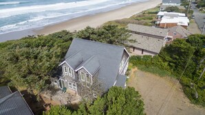 Un área residencial costera con casas cerca de la playa, que presenta una combinación de edificios de uno y varios pisos, rodeada de vegetación.