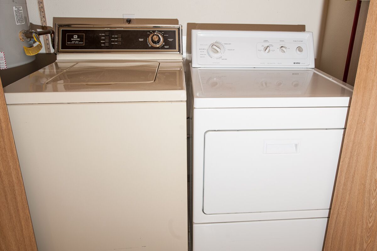 A laundry room with two stacked washers and dryers.