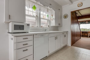 Kitchen features a window with a view of the outdoors, a microwave, and a dishwasher.