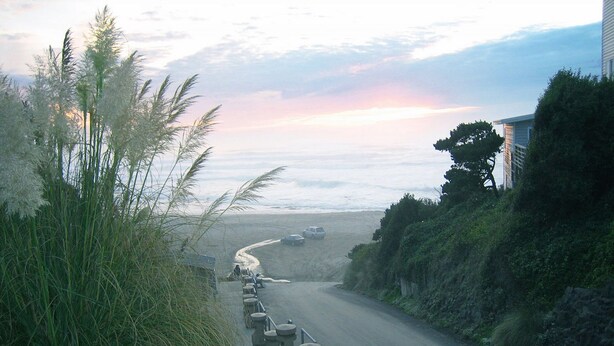 A coastal road with a sidewalk, a railing, and a beach in the background. - Spacious home, easy beach access, central location close to local attractions (Lincoln City)