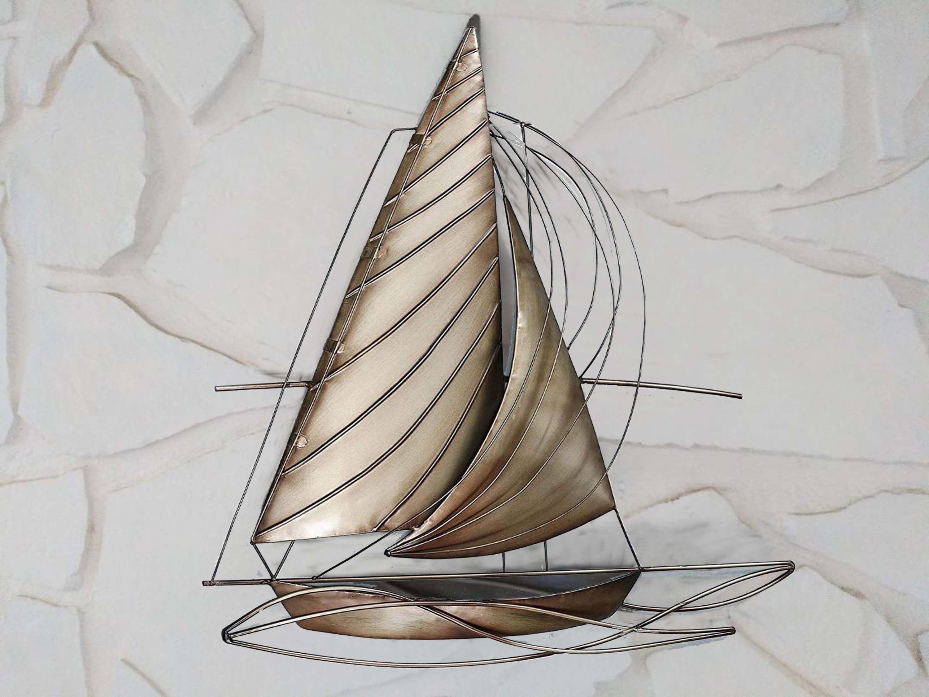A sailboat sculpture against a textured wall.