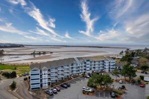 A multi-story hotel with a parking lot and a view of the beach and ocean. - Stunning views, easy beach access from this bay front condo in the Taft District (Lincoln City)