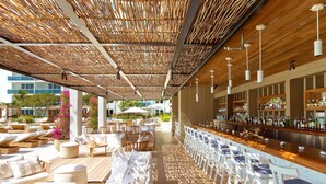 A covered outdoor bar area with lounge seating and a bar counter. - 1 Homes Vacation Rentals by LMC (Miami Beach)