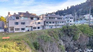 A multi-story residential building with a flat roof and a balcony on the second floor.