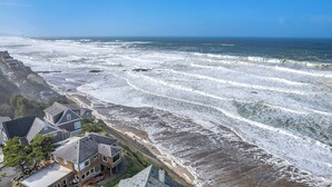A coastal property with a view of the sea, featuring multiple houses with sloped roofs and a rocky shoreline. - Sweeping ocean views for your families getaway with easy access to great beaches (Lincoln City)