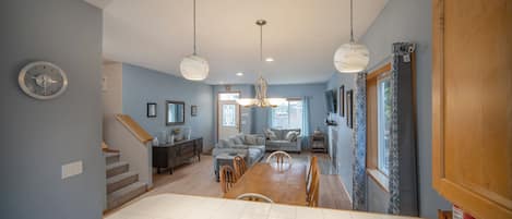 Un grand espace de vie comprenant une salle à manger, un escalier et une cuisine.