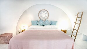 A bedroom with a large bed, a round wall hanging, and a ladder against the wall. - B&B Fico d'India (Polignano a Mare)