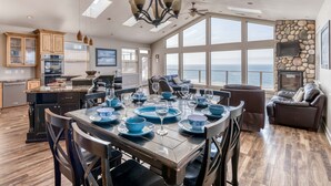 Un comedor amplio con una mesa grande dispuesta para seis personas, con vistas a un paisaje marino.