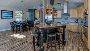 Una cocina moderna con armarios de madera, una isla central y taburetes de bar.