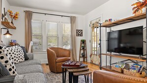 Een woonkamer met een bank, fauteuil, salontafel en tv-meubel.