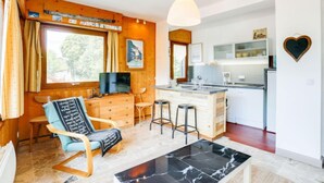 Un espace de vie compact comprenant une cuisine, un coin repas et un coin salon.