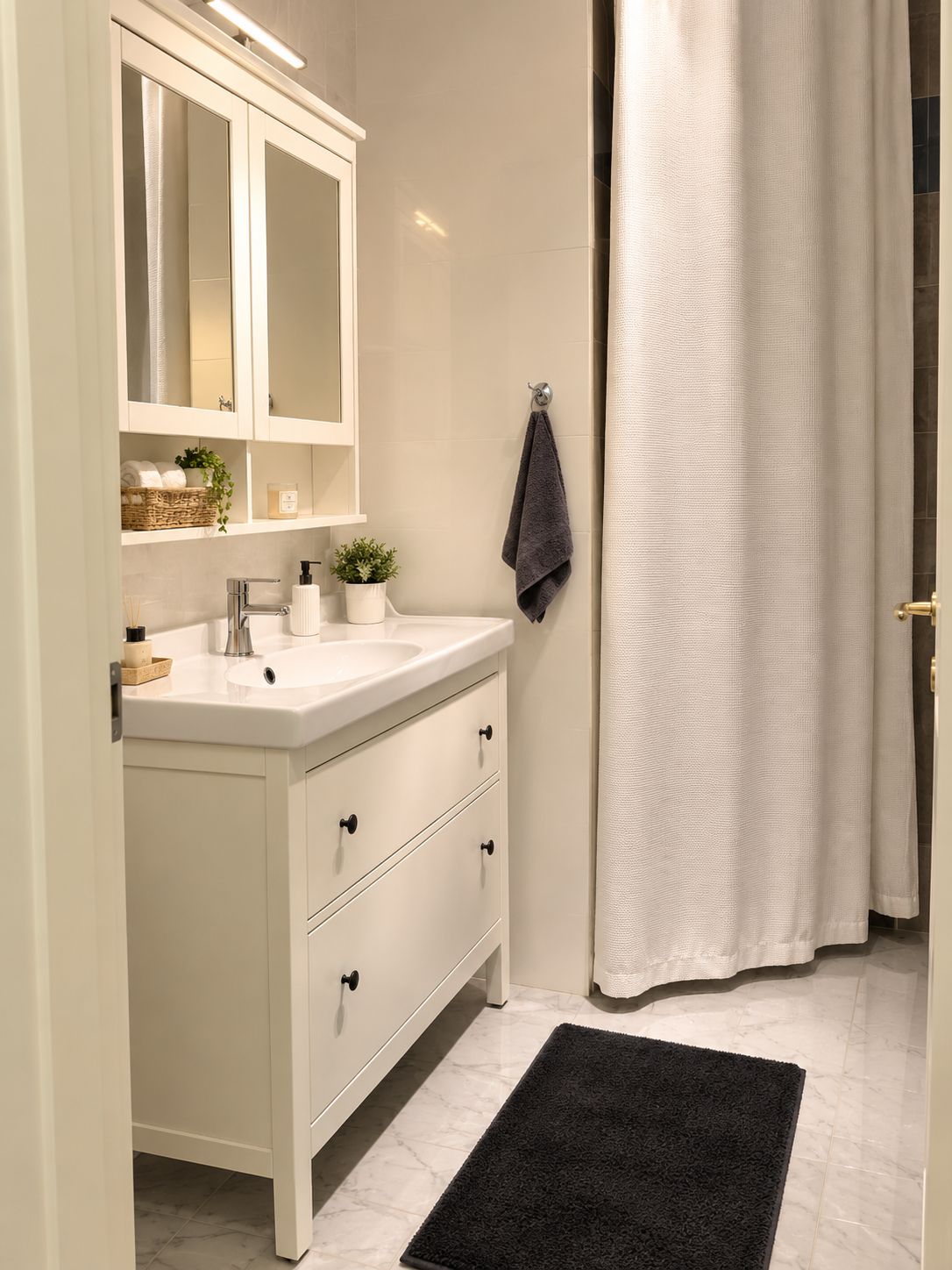 A bathroom with a white vanity, a mirror, a towel rack, and a shower curtain.