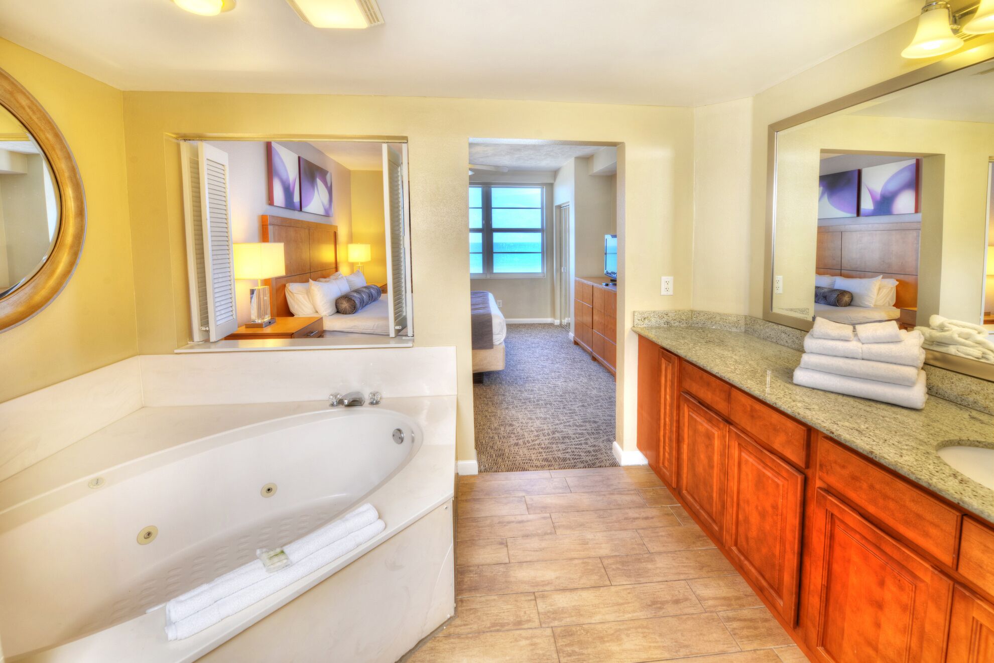 Une salle de bain moderne avec une grande baignoire, un meuble-lavabo en bois et un miroir.
