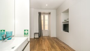 Ein Badezimmer mit einem weißen Waschbecken, einem Spiegel und einem grünen Erste-Hilfe-Schild.