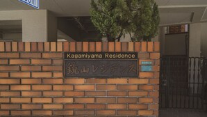 Un mur de briques sur lequel on peut lire l’inscription « Résidence Kagamiya » et une autre inscription en caractères japonais.