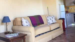 Ein Wohnzimmer mit einer Couch, einem kleinen Tisch und einer Treppe.