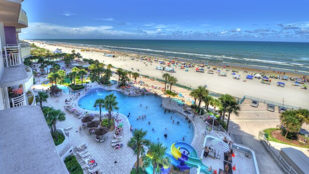 A resort with a pool area, beach, and ocean view.