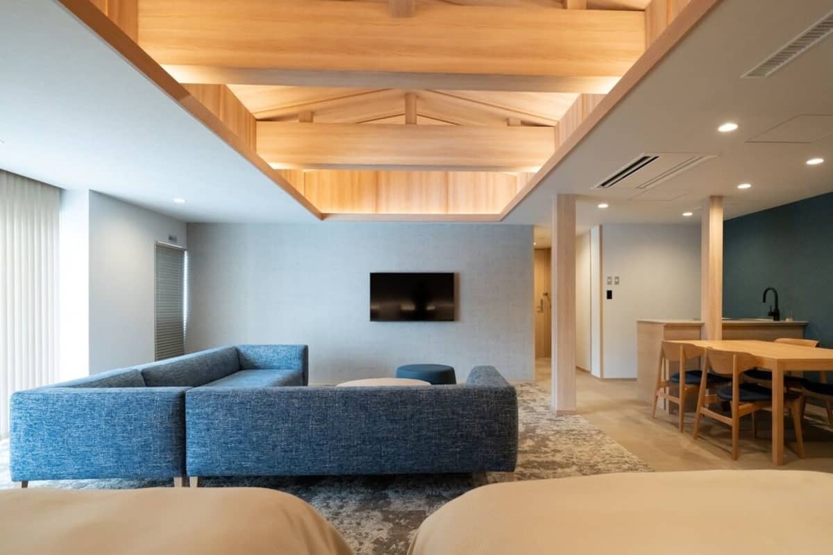 A modern room with a sofa, a dining table, and a TV.
