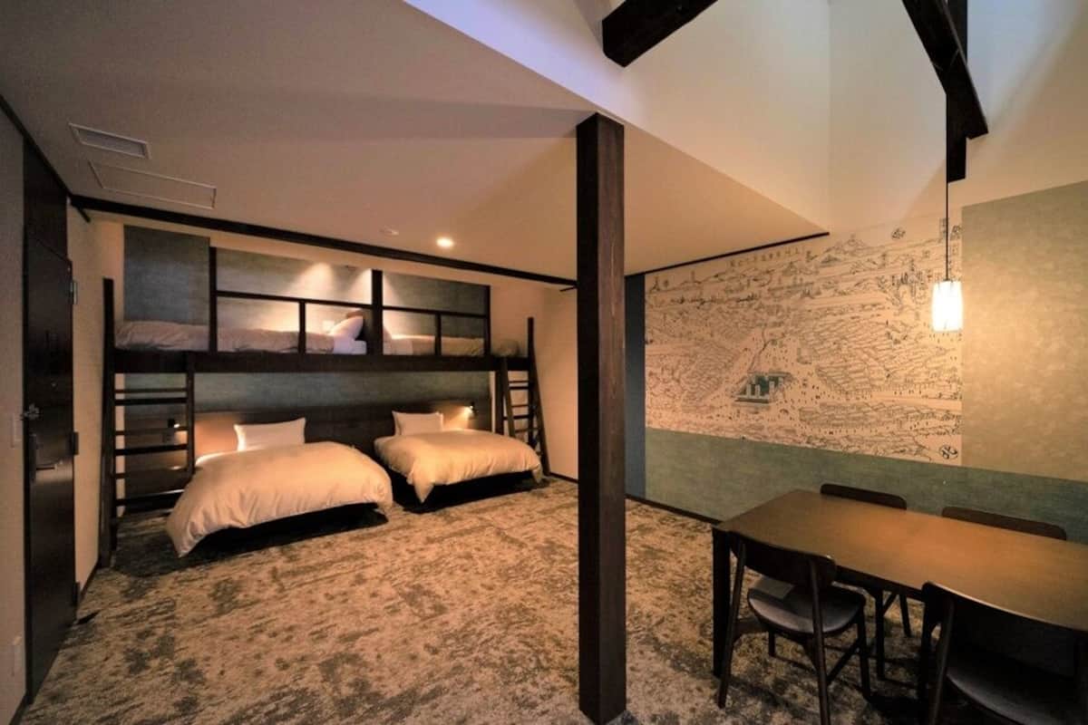 A room with bunk beds, a dining table, and a large map on the wall.