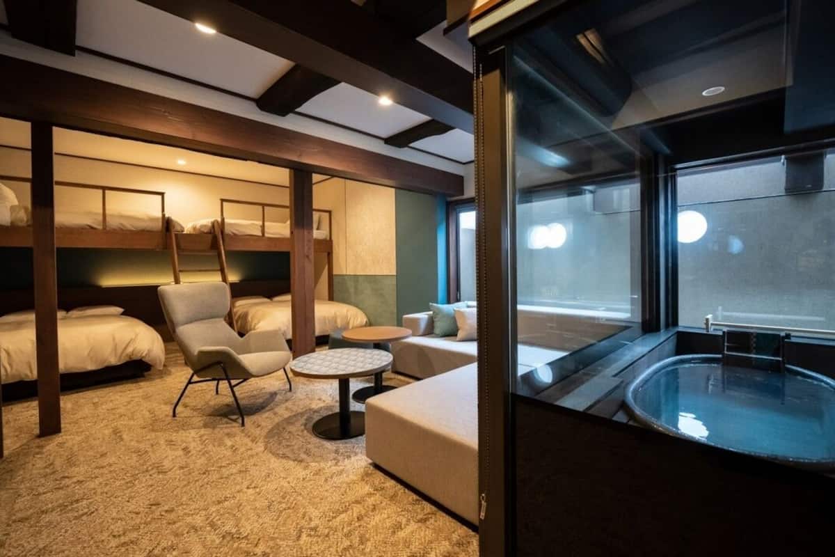A cabin with bunk beds, a sofa, a round table, and a bathtub.