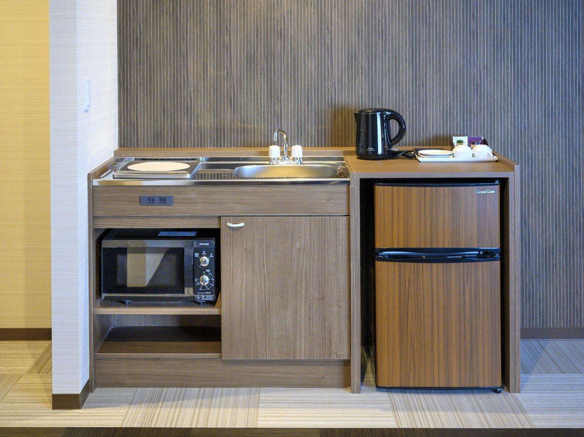 A compact kitchenette with a microwave, sink, and refrigerator.