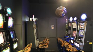 A room with slot machines, bar stools, and a mirror on the wall. - Kerwick Hotel (Redbank)