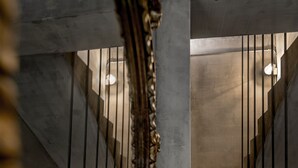 Un escalier avec une rampe en métal et un cadre de miroir décoratif.